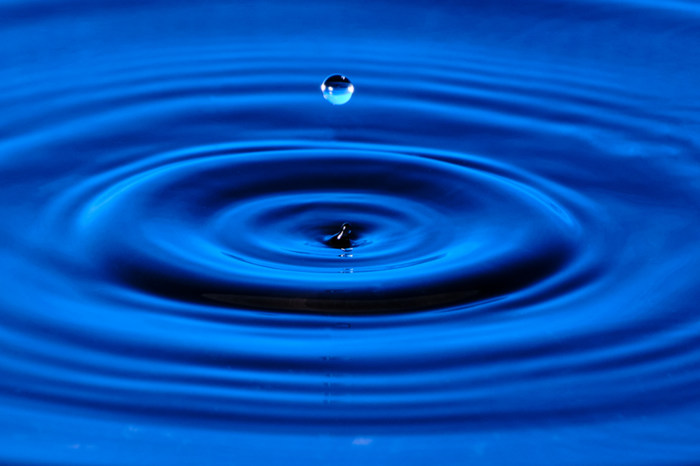 splash-drop-water-with-diverging-water-circles-blue-background 1
